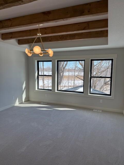 unfurnished room with carpet, beam ceiling, baseboards, and an inviting chandelier