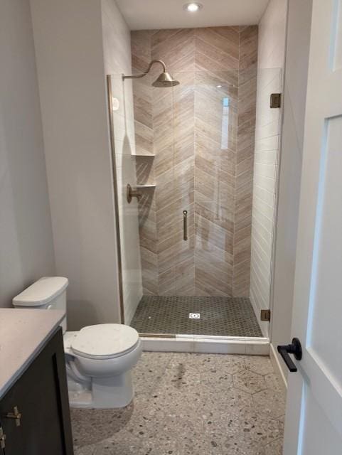 full bath featuring toilet, a shower stall, and vanity