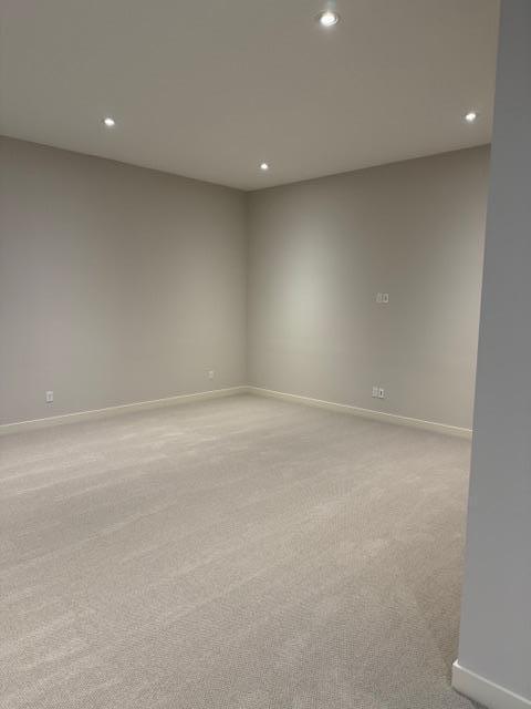 spare room featuring recessed lighting, baseboards, and light colored carpet