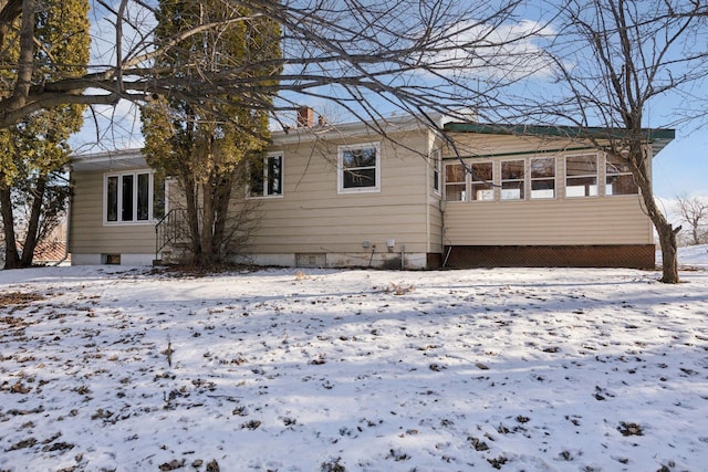 view of snow covered back of property