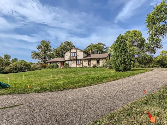 tudor home with a front lawn