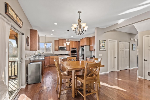 dining room featuring sink, a chandelier, and dark hardwood / wood-style flooring