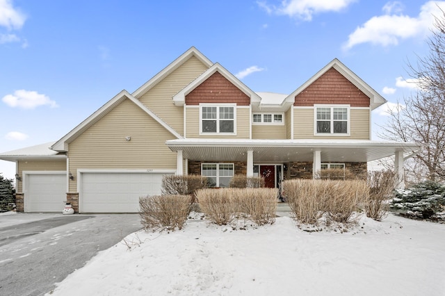 view of front of property featuring a porch, an attached garage, and aphalt driveway