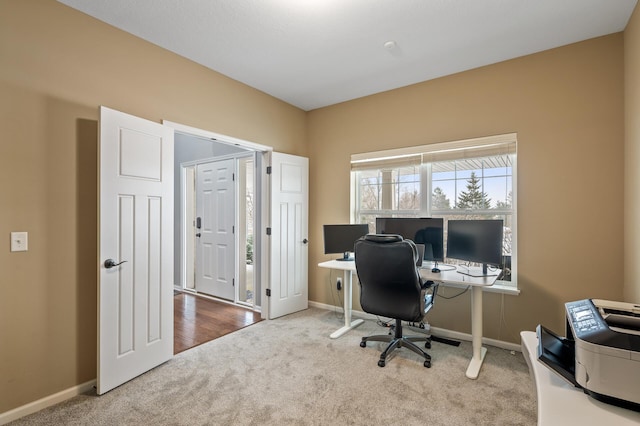 carpeted office space featuring baseboards