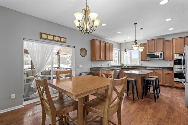 dining space featuring a chandelier, recessed lighting, wood finished floors, visible vents, and baseboards