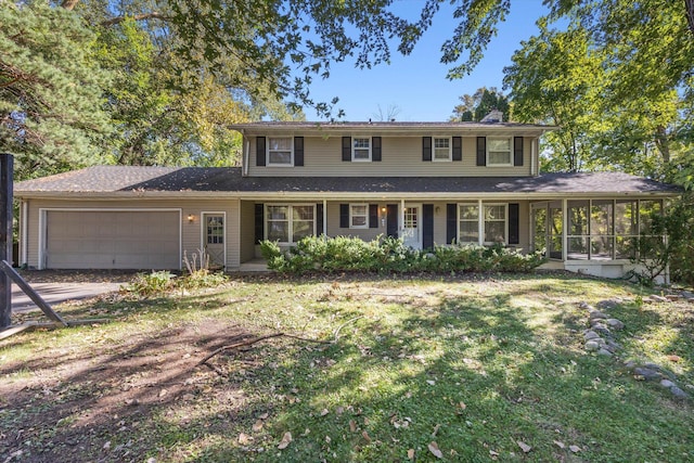 view of front of house featuring a garage, a sunroom, and a front yard