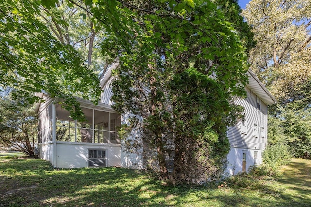 view of property exterior featuring a sunroom and a lawn