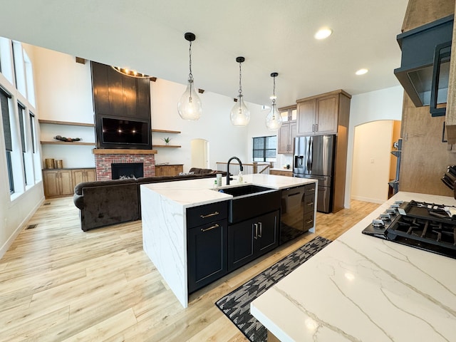106 19th St NE, Barnesville, MN 56514 - kitchen featuring black appliances, exhaust hood, light wood finished floors, hanging light fixtures, and light stone countertops