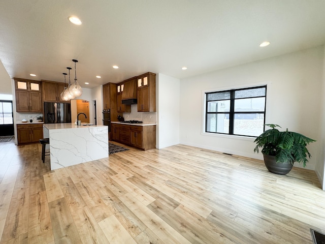 106 19th St NE, Barnesville, MN 56514 - kitchen featuring refrigerator with ice dispenser, recessed lighting, tasteful backsplash, glass insert cabinets, and light wood-type flooring