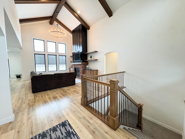 106 19th St NE, Barnesville, MN 56514 - staircase with high vaulted ceiling, beamed ceiling, a fireplace, a chandelier, and wood-type flooring