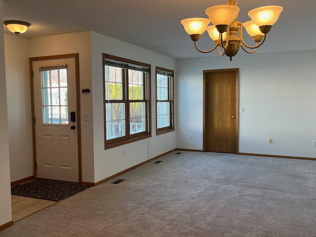 doorway to outside with carpet floors and a notable chandelier