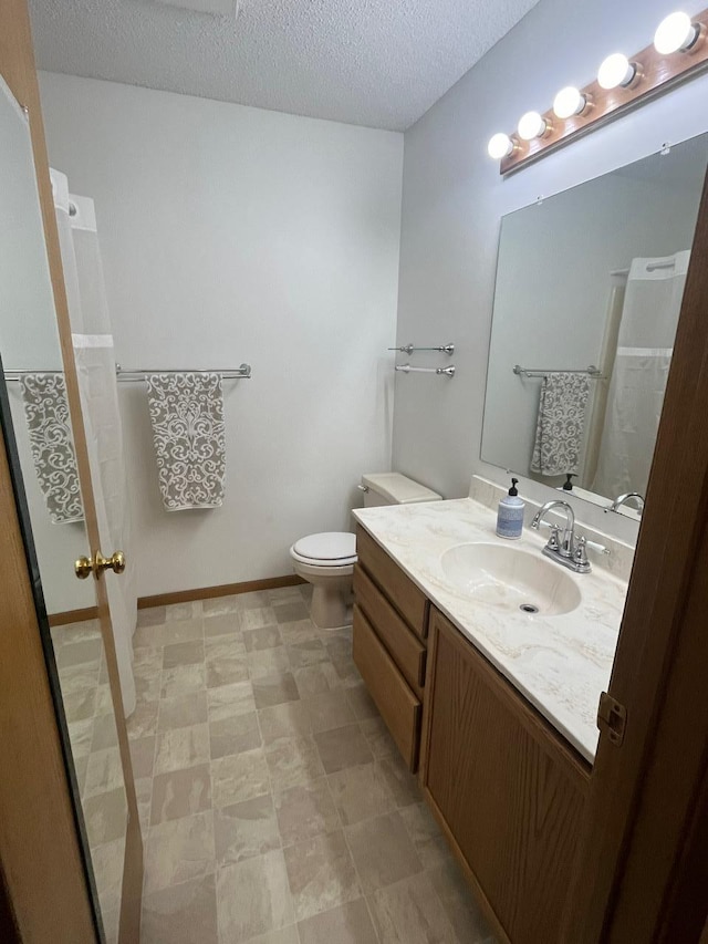 bathroom with vanity, curtained shower, a textured ceiling, and toilet