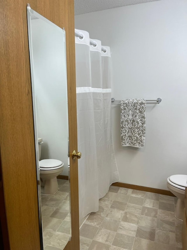 bathroom featuring toilet and a textured ceiling