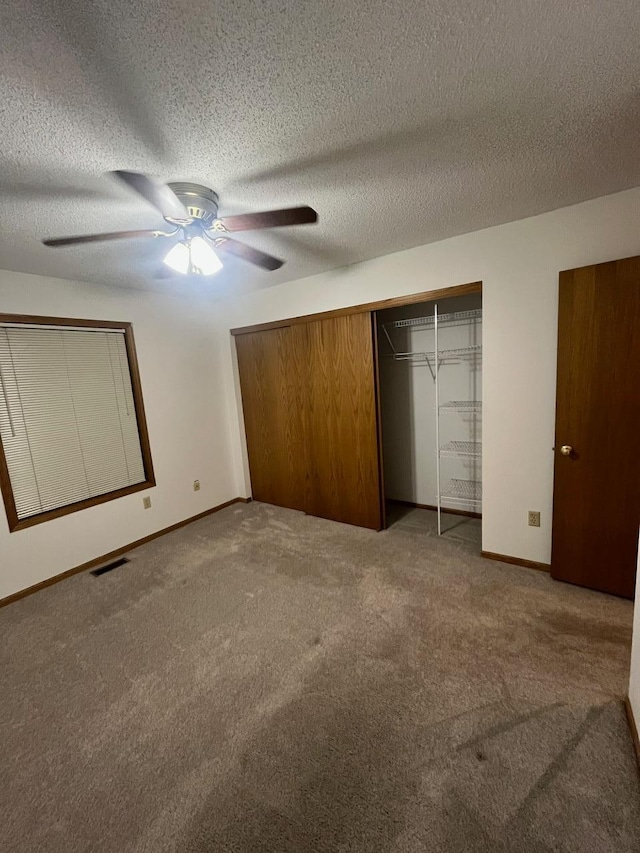 unfurnished bedroom featuring a textured ceiling, a closet, ceiling fan, and carpet flooring