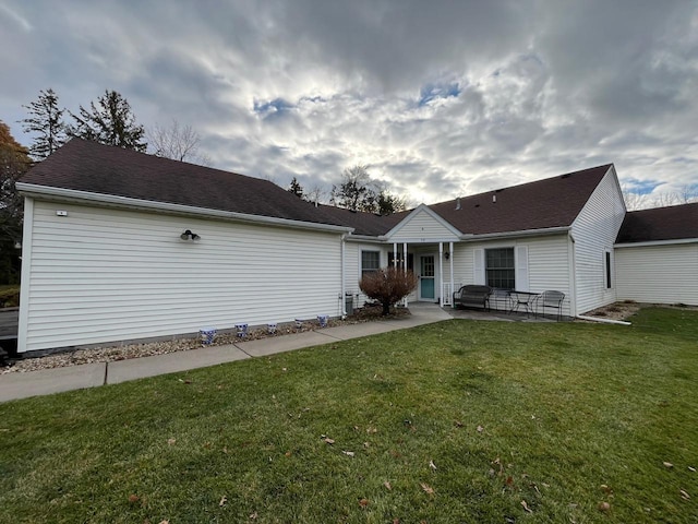 back of property featuring a lawn and a patio