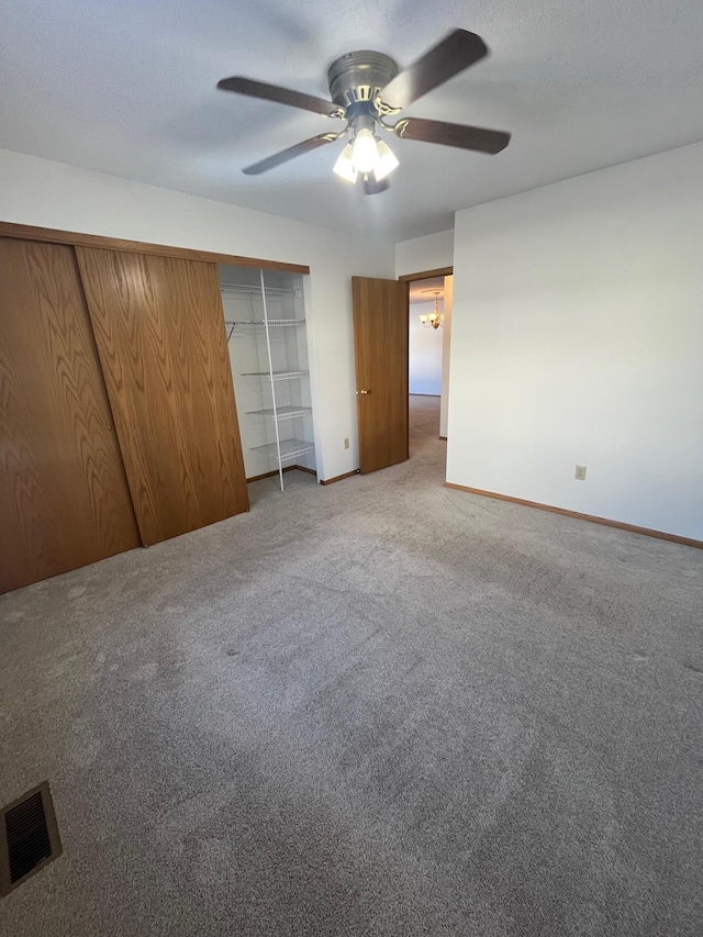 unfurnished bedroom with baseboards, visible vents, ceiling fan, a textured ceiling, and carpet flooring