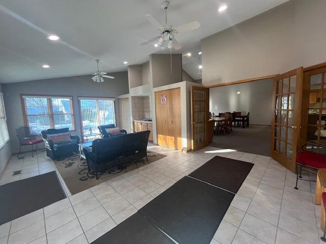 interior space with high vaulted ceiling, a ceiling fan, recessed lighting, french doors, and light tile patterned floors