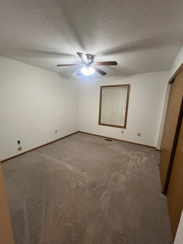 unfurnished bedroom with visible vents, ceiling fan, baseboards, and carpet floors