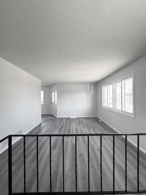 spare room featuring hardwood / wood-style flooring and a textured ceiling