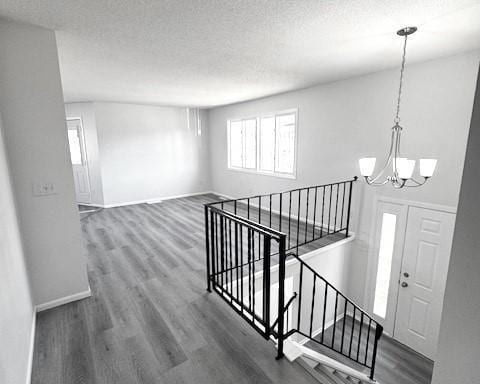 interior space featuring dark hardwood / wood-style flooring, a chandelier, and a textured ceiling