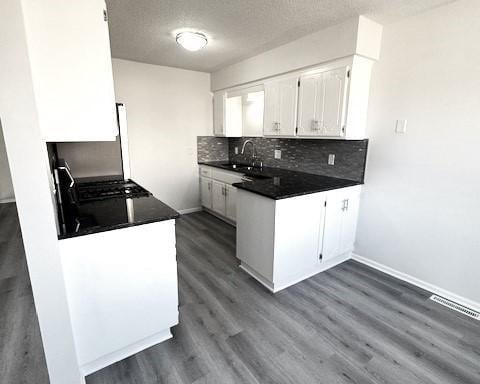 kitchen featuring tasteful backsplash, sink, white cabinets, and dark hardwood / wood-style floors