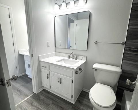 bathroom with vanity, hardwood / wood-style floors, and toilet