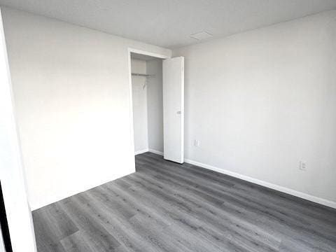 unfurnished bedroom with dark hardwood / wood-style flooring and a closet