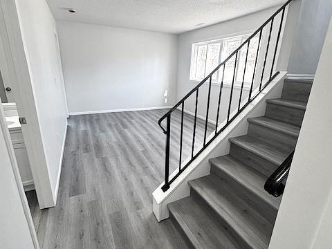 stairs with hardwood / wood-style flooring and a textured ceiling