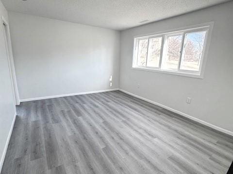 spare room featuring dark hardwood / wood-style floors and a textured ceiling