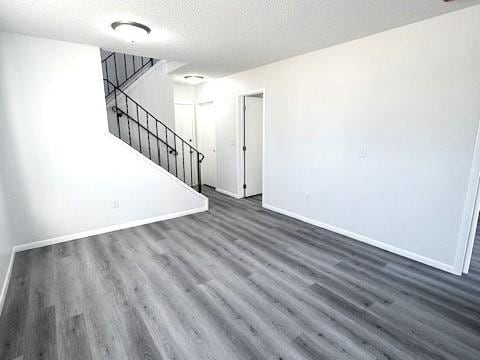 unfurnished living room with dark hardwood / wood-style floors and a textured ceiling