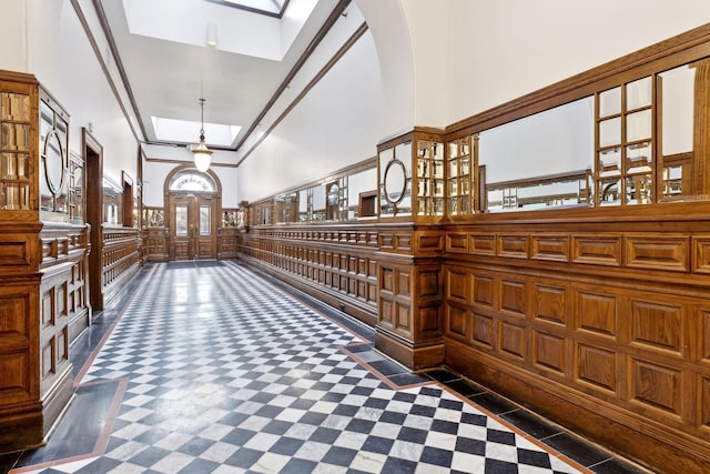 hallway with a high ceiling and a skylight