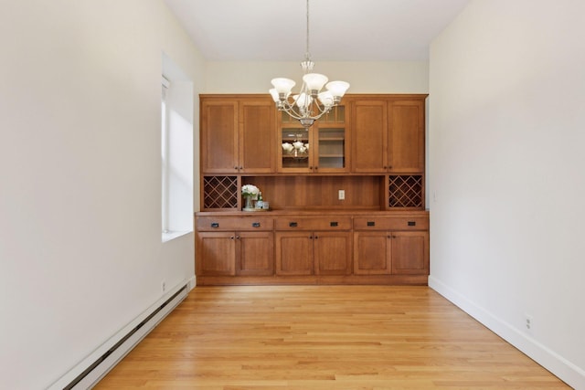 unfurnished dining area with a chandelier, baseboard heating, and light hardwood / wood-style flooring