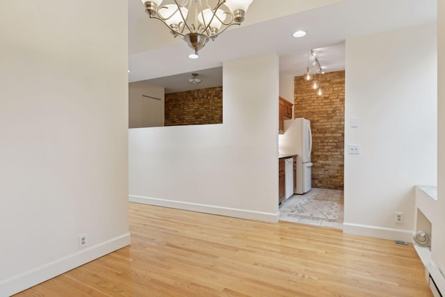 spare room with a chandelier and light hardwood / wood-style flooring