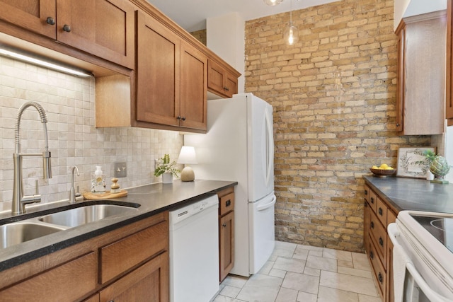 kitchen featuring sink, white appliances, tasteful backsplash, brick wall, and decorative light fixtures