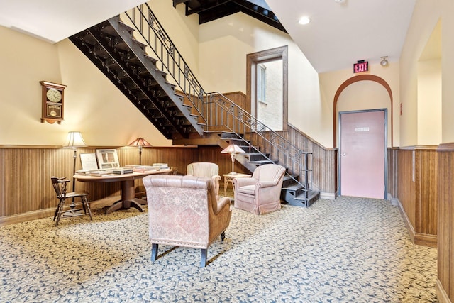 carpeted living room with wooden walls