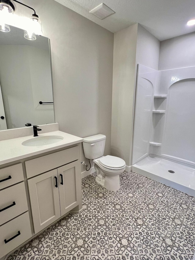 bathroom with walk in shower, vanity, and toilet