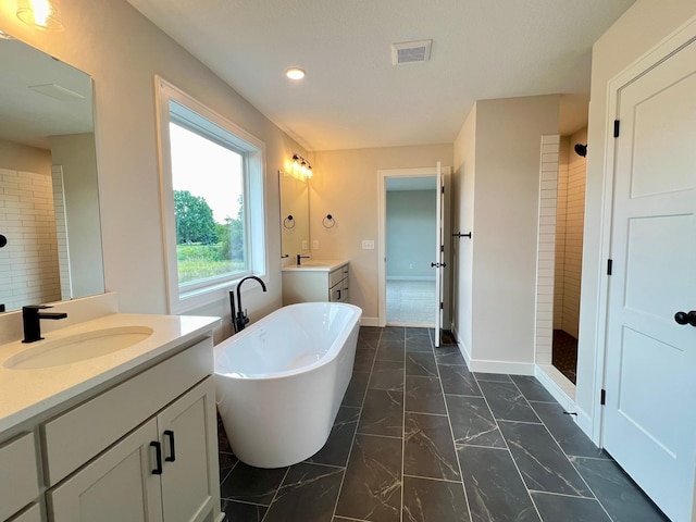 bathroom with vanity and independent shower and bath