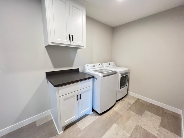 washroom with cabinets and washer and clothes dryer