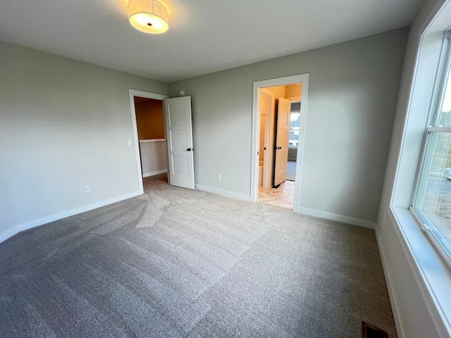 unfurnished bedroom with multiple windows and light colored carpet