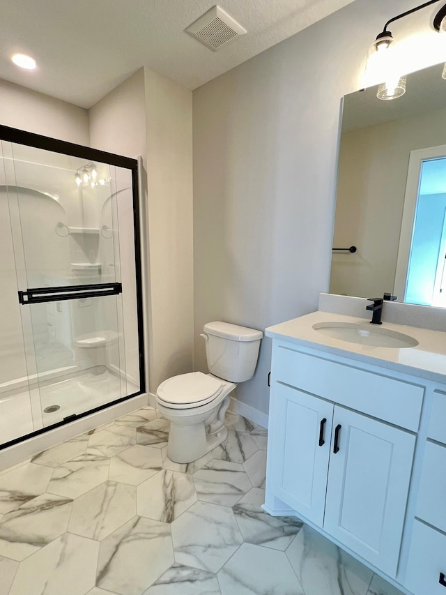 bathroom with vanity, toilet, and a shower with shower door