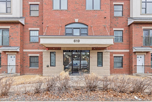 view of exterior entry featuring brick siding