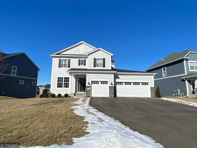 view of property featuring a garage and a lawn