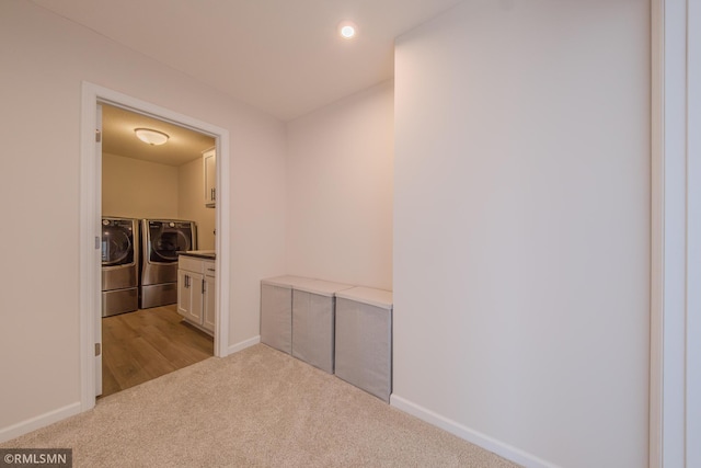 hall featuring independent washer and dryer and light colored carpet