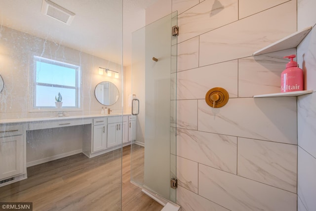 bathroom featuring vanity, a shower with shower door, and hardwood / wood-style floors