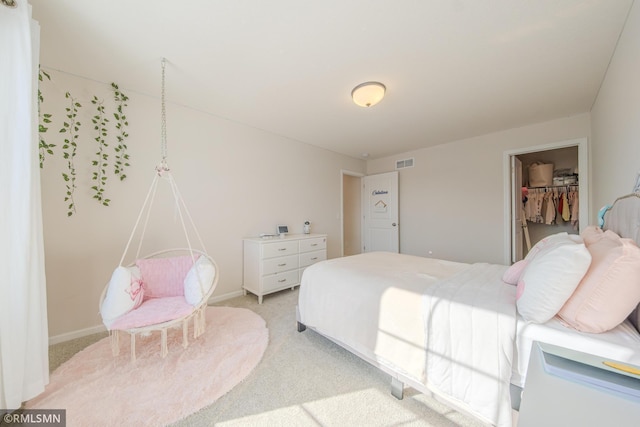 bedroom with a walk in closet, light colored carpet, and a closet