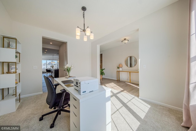 office space with an inviting chandelier and light carpet