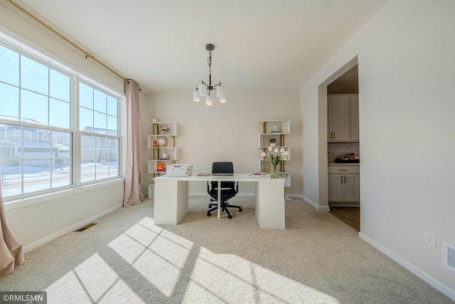 office space with light carpet and a chandelier