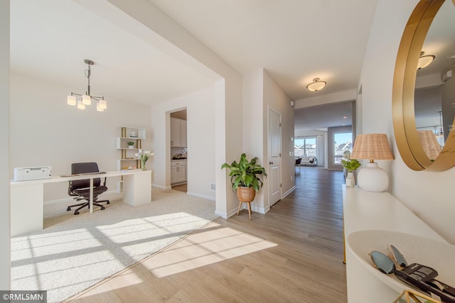 home office with light hardwood / wood-style floors