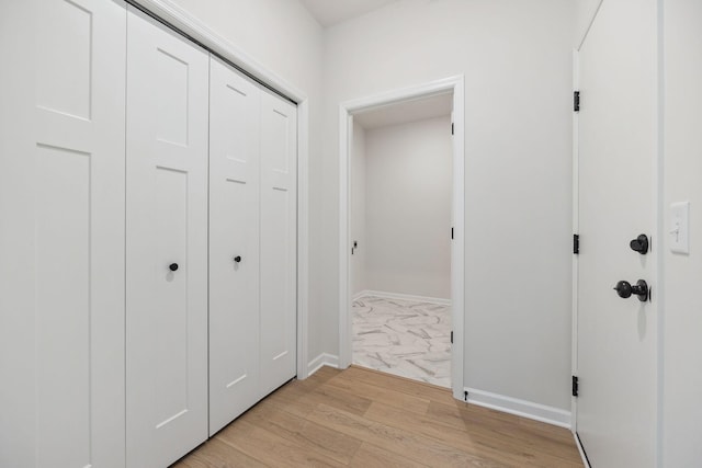 corridor with light hardwood / wood-style flooring