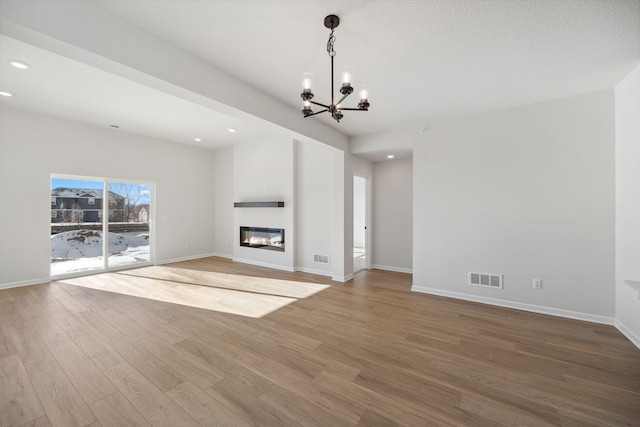 unfurnished living room featuring hardwood / wood-style floors and a notable chandelier